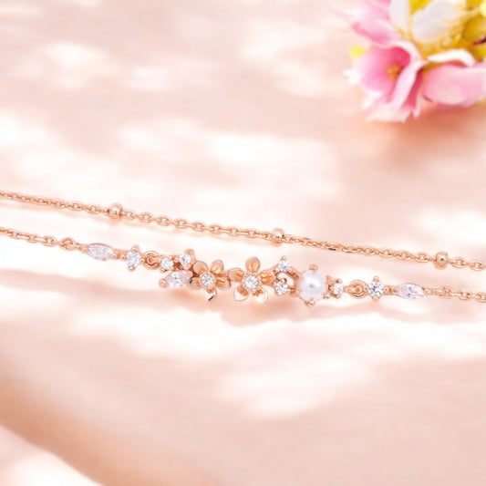 This image shows a beautiful piece of jewelry. It consists of a delicate rose gold necklace with a row of delicate flower-shaped brackets set with zircons and pearls.
